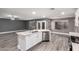 Modern kitchen with an island, stainless steel appliances, gray walls, white cabinets, and granite countertops at 5754 W Larkspur Dr, Glendale, AZ 85304