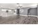 Open-concept living space with light gray paint, wood-look tile, white trim, and a ceiling fan at 5754 W Larkspur Dr, Glendale, AZ 85304