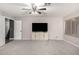Spacious living room with neutral walls, modern ceiling fan, and a cabinet underneath the mounted tv at 5754 W Larkspur Dr, Glendale, AZ 85304
