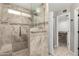 Walk-in shower with stone surround, grab bar, overhead shower head, and seating at 5754 W Larkspur Dr, Glendale, AZ 85304