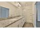 Bright bathroom featuring a double vanity with granite counters, glass shower, and modern fixtures at 7531 E Billings St # 131, Mesa, AZ 85207