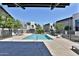 Community pool area surrounded by modern townhomes, lounge chairs, and landscaped fencing at 7531 E Billings St # 131, Mesa, AZ 85207
