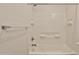Bright white shower with tiled walls, an adjustable shower head, and built in shelves at 7531 E Billings St # 131, Mesa, AZ 85207