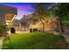 Spacious backyard with outdoor dining area and grill, seating, lush green lawn, and beautiful lighting at 7631 N 20Th St, Phoenix, AZ 85020