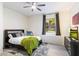 Cozy bedroom with ceiling fan, plush rug, and window with serene outdoor view at 7631 N 20Th St, Phoenix, AZ 85020