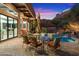 Outdoor dining patio area with waterfall feature next to covered porch with lounge chairs at 7631 N 20Th St, Phoenix, AZ 85020