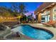 Beautiful pool with stone features and waterfall near patio with lounge chairs and outdoor dining at 7631 N 20Th St, Phoenix, AZ 85020