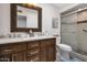 Bathroom with a double vanity, wood cabinets, and a glass-enclosed shower at 8719 E San Marino Dr, Scottsdale, AZ 85258