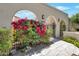 Inviting front entrance with beautiful bougainvillea, wrought iron gate, and arched walkway at 8719 E San Marino Dr, Scottsdale, AZ 85258