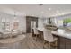 Stylish kitchen island with bar seating, stainless steel refrigerator, and white cabinetry, flooded with natural light at 8719 E San Marino Dr, Scottsdale, AZ 85258