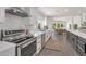 Modern kitchen with stainless steel appliances, white cabinets, and an open layout to dining area at 8719 E San Marino Dr, Scottsdale, AZ 85258