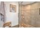Tiled shower with glass door, featuring decorative accents and a convenient bench at 8719 E San Marino Dr, Scottsdale, AZ 85258