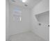 Well lit laundry room with shelving and white tile flooring at 8865 W Orange Dr, Glendale, AZ 85305