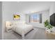 Bright main bedroom with a large window, neutral decor, plush rug, and a TV for relaxing at 8865 W Orange Dr, Glendale, AZ 85305
