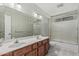 Bathroom featuring a double sink vanity and tiled shower at 8911 E Sutton Dr, Scottsdale, AZ 85260