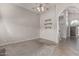 Bright and airy living room featuring carpet, floating shelves, and an arched doorway leading to the kitchen at 8911 E Sutton Dr, Scottsdale, AZ 85260