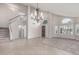 Bright and airy living room featuring tile flooring, carpet, a statement chandelier, and a staircase at 8911 E Sutton Dr, Scottsdale, AZ 85260
