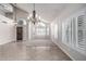 Bright and airy living room featuring tile flooring, carpet, a statement chandelier, and shuttered windows at 8911 E Sutton Dr, Scottsdale, AZ 85260