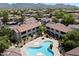 Aerial view of a community pool with a hot tub and lush landscaping with beautiful mountain views at 9555 E Raintree Dr # 1055, Scottsdale, AZ 85260