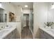 Bright bathroom featuring dual sinks, walk-in closet, and glass shower at 9555 E Raintree Dr # 1055, Scottsdale, AZ 85260