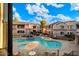 Aerial view of community pool with tables, lounge chairs, and low-rise residential buildings at 9555 E Raintree Dr # 1055, Scottsdale, AZ 85260