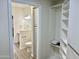 Hallway featuring bathroom with toilet, cabinets, sink and mirror plus view to shelving storage unit at 9555 E Raintree Dr # 1055, Scottsdale, AZ 85260