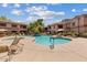 Community pool with plenty of lounge chairs, umbrellas, and manicured desert landscaping at 9555 E Raintree Dr # 1055, Scottsdale, AZ 85260