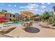 Well-maintained community pool area featuring lounge chairs, tables and desert landscaping at 9555 E Raintree Dr # 1055, Scottsdale, AZ 85260