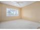 Bright bedroom with a ceiling fan and a large window with views of palm trees at 9649 E Holiday Way, Sun Lakes, AZ 85248