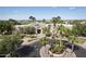 Grand clubhouse entrance with palm trees, lush landscaping, and a circular driveway at 9649 E Holiday Way, Sun Lakes, AZ 85248