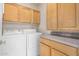 Functional laundry room with washer, dryer, ample cabinet storage, and a countertop at 9649 E Holiday Way, Sun Lakes, AZ 85248