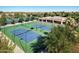 Aerial view of well-maintained tennis courts surrounded by lush greenery and a clubhouse at 9649 E Holiday Way, Sun Lakes, AZ 85248