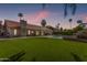 Spacious backyard featuring a green lawn, swimming pool, and mature trees at 9736 E Ironwood Dr, Scottsdale, AZ 85258
