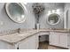 Bright bathroom with dual sinks, granite counters, and white cabinets, accented by decorative mirrors and fixtures at 9736 E Ironwood Dr, Scottsdale, AZ 85258