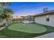 Beautiful backyard features a putting green, covered patio, and well maintained landscaping at 10743 W Frier Dr, Glendale, AZ 85307