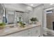 Bathroom featuring double sinks, quartz countertops, and a tiled shower at 10743 W Frier Dr, Glendale, AZ 85307