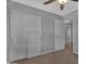 This bedroom has neutral walls, plush carpet, a fan, and a closet for extra storage at 10743 W Frier Dr, Glendale, AZ 85307