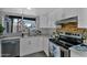 Well-lit kitchen includes stainless steel appliances, white cabinetry, and a view to the backyard at 10743 W Frier Dr, Glendale, AZ 85307