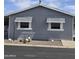 Well-maintained gray home features desert landscaping, awnings, and white trim at 11411 N 91St Ave # 75, Peoria, AZ 85345