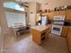 Functional kitchen with an island, eat-in dining area, tile floors, and good light at 1612 E Barbarita Ave, Gilbert, AZ 85234