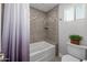 Tiled bathroom featuring a tub, shower, and a decorative niche for toiletries at 1744 E Huber St, Mesa, AZ 85203