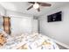 Bright bedroom offering a ceiling fan, closet, and mounted TV at 1744 E Huber St, Mesa, AZ 85203