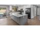 Modern kitchen with white cabinets, stainless steel appliances, and a large island with a sink and breakfast bar seating at 1744 E Huber St, Mesa, AZ 85203