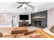 Comfortable living room is complete with a ceiling fan, TV, stylish fireplace, and cozy furniture at 1744 E Huber St, Mesa, AZ 85203