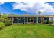 Spacious backyard with lush green lawn, covered patio, blue brick exterior and colorful flowers at 2219 W Catalina Dr, Phoenix, AZ 85015
