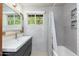 Elegant bathroom features a stylish vanity, framed mirror, and a tiled shower with black and white accents at 2219 W Catalina Dr, Phoenix, AZ 85015