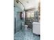 Stylish bathroom featuring a glass-enclosed shower, modern vanity, and unique floor tiles at 2219 W Catalina Dr, Phoenix, AZ 85015