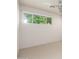 Bright bedroom featuring neutral walls and a window with a lush green view, tiled floor at 2219 W Catalina Dr, Phoenix, AZ 85015
