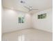 Bright, modern bedroom with neutral walls, tile floors, and natural light from two windows at 2219 W Catalina Dr, Phoenix, AZ 85015