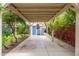 Charming carport design with hanging light fixture, concrete slab, and lush landscaping around the perimeter at 2219 W Catalina Dr, Phoenix, AZ 85015